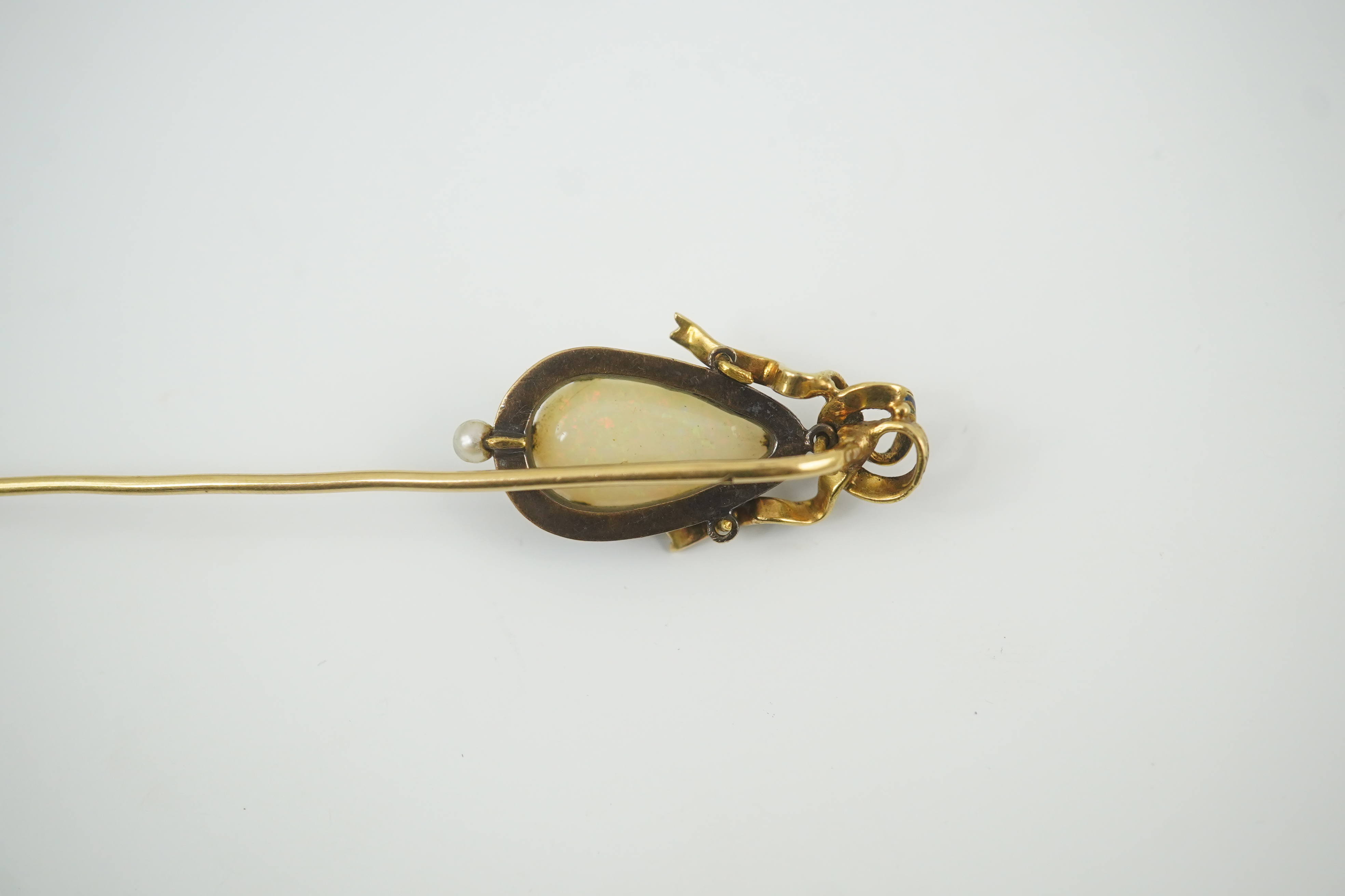 A late Victorian gold, white opal, seed pearl diamond chip and blue enamel set stick pin